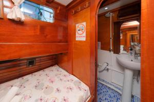 a small bathroom with a sink and a bed at Sufi boat in Fethiye