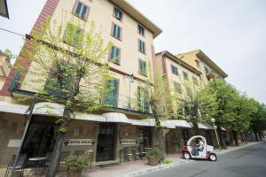 un pequeño coche aparcado frente a un edificio en Hotel Giglio, en Montecatini Terme