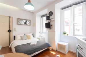 a bedroom with a bed in a white room at Lisbon Mouraria Apartment in Lisbon