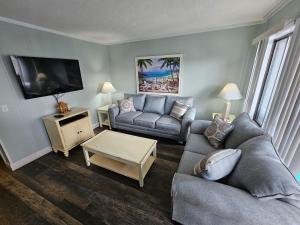 a living room with a couch and a tv at Myrtle Beach Resort- Unit A 428 in Myrtle Beach