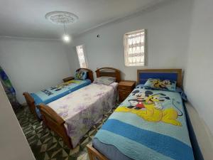 two beds in a room with two beds sidx sidx sidx at Au cœur du Médina in Fez