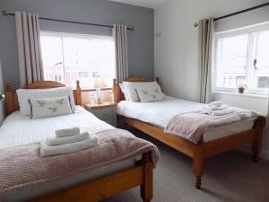 a bedroom with two beds with towels on them at Double Award Winning, Stunning 1700's Grd 2 listed cottage near Stonehenge - Elegantly Refurbished Throughout in Amesbury