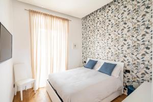 ein Schlafzimmer mit einem weißen Bett mit blauen Kissen in der Unterkunft Casa Borghese - Your perfect stay in Rome in Rom