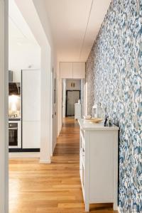 - une cuisine avec des placards blancs et du papier peint bleu et blanc dans l'établissement Casa Borghese - Your perfect stay in Rome, à Rome