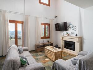 a living room with two couches and a fireplace at Villa Aura Pine in Agia Pelagia