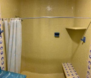 y baño con ducha y cortina de ducha. en El Rincón de Granada Hotel en Cali