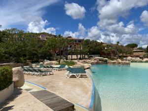 una piscina con sedie a sdraio e un resort di Appt Climatisé Vue Mer Club P&V Restanques Golfe de Saint-Tropez - Les Roses - Grimaud a Grimaud