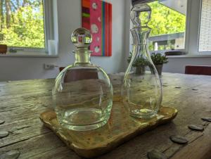 twee glazen flessen zittend op een houten tafel bij Luxe bungalow "Zomeroord" in Beekbergen