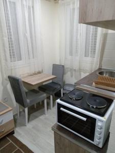 布德瓦的住宿－Studio apartman Mušura，厨房配有炉灶和桌椅