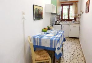 een keuken met een tafel met een blauw en wit tafelkleed bij Apartments Papadioti in Pefki