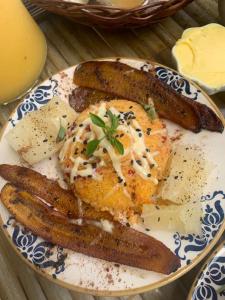un plato de comida con huevos y salchichas en una mesa en Mais Que Nada Itacaré - Hostel, Bar & Breakfast en Itacaré