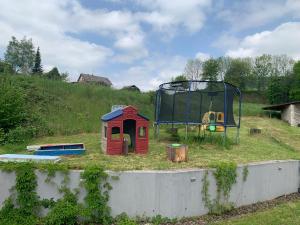 uma área de lazer com um aro e um parque infantil em Apartman s bazénem a saunou em Kadaň