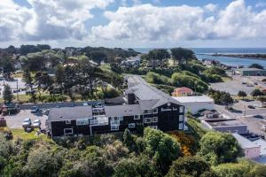 an aerial view of a building on a hill next to the ocean at Bandon Inn in Bandon