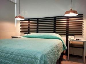 1 dormitorio con 1 cama, escritorio y 2 luces en Angeles Suites & Hotel en Veracruz