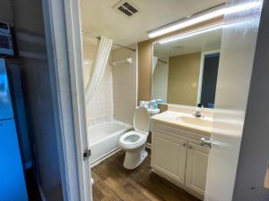 a bathroom with a toilet and a sink and a mirror at Oceanfront Viking Motel in Myrtle Beach +16 photos