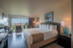 a hotel room with a large bed and a balcony at Bandon Inn in Bandon