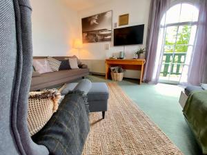 ein Wohnzimmer mit Sofa und Fernseher in der Unterkunft Vanilla Hof in Naumburg + 78 Fotos