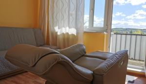 een woonkamer met een leren bank en een raam bij Mango Lu z balkonem, plaża 300m in Sopot