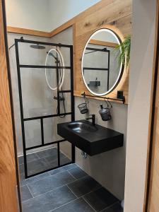 a bathroom with a black sink and a mirror at Mountain Homes in Bönigen