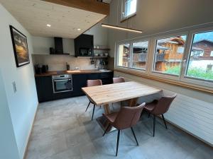 a kitchen with a wooden table and some chairs at Mountain Homes in Bönigen