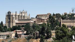 a group of buildings on top of a hill at El puente de San Martín con parking gratis in Toledo