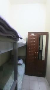Zimmer mit einem Schreibtisch und einer Tür mit einem Spiegel in der Unterkunft Bunk bed private room Avani in Dubai