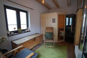 a room with a wooden tub and a chair at Drevenica Harmony so saunou in Ružomberok