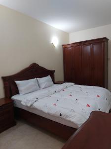 a bedroom with a large bed with a wooden headboard at Julie's Marvelous home in Dar es Salaam
