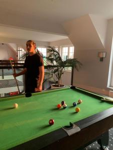a man standing next to a pool table at Apartamenty M&M in Mikołajki