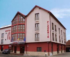 um edifício branco e vermelho com um sinal em Hotel Lucy Star em Cluj-Napoca