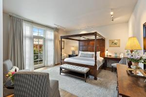 McCully House Inn في جاكسونفيل: غرفة نوم بسرير مظلة وغرفة معيشة