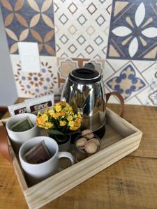 a tray with a coffee pot and flowers on a table at Alto da Villa in Ouro Preto