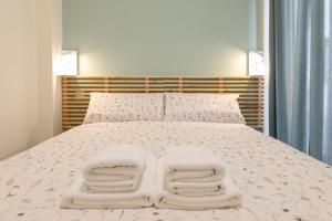 1 dormitorio con 1 cama con 2 toallas en Bosco Eco Living, en Sevilla