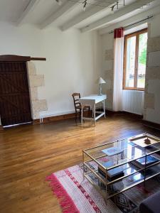 an empty living room with a table and a glass table at La Colline aux Licornes in Montbron