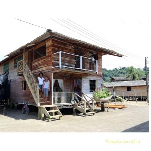 two people standing on the stairs of a house at Posada Jurubirá in Nuquí