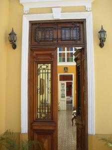 een houten deur in een kamer met een gele muur bij Residencial Miraflores B&B in Lima