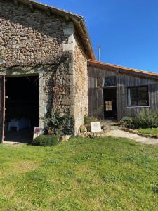 an old stone building with a large garage at La Colline aux Licornes in Montbron