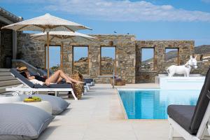 カラファティスにあるEthereal Villa Mykonosのスイミングプール横の椅子に横たわる女