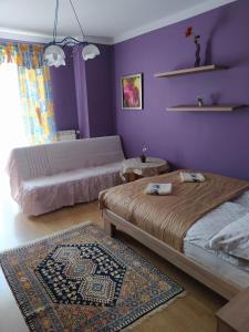 1 dormitorio con 2 camas y pared púrpura en Apartament Suwalski Zakątek, en Suwałki
