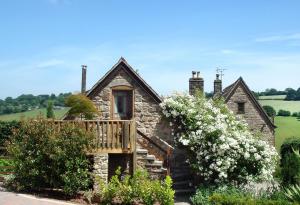 an old stone house with a balcony and flowers at Brambles in Little Dean