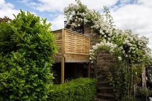 a tree house with a deck on top of it at Brambles in Little Dean