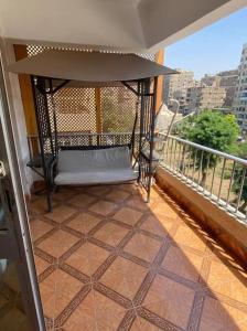 une terrasse couverte avec un hamac sur un balcon dans l'établissement Boho Chic Retreat in the midst of City Life, au Caire