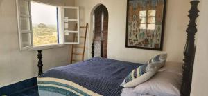 a bedroom with a bed and a window at Hotel-Restaurant Le Kaouki in Sidi Kaouki