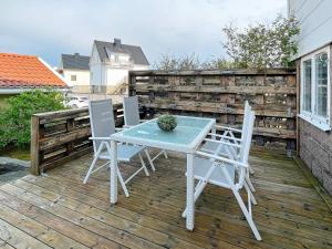 een tafel en stoelen op een terras met een potplant bij Holiday home KUNGSHAMN XIV in Kungshamn