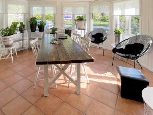 comedor con mesa de madera y sillas en Holiday home SÖLVESBORG XVI, en Sölvesborg