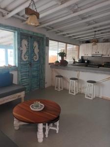 a living room with a table and a kitchen at Casa QUNCHU in Canoas De Punta Sal