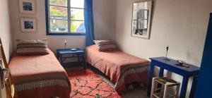 a bedroom with two beds and a window at Hotel-Restaurant Le Kaouki in Sidi Kaouki
