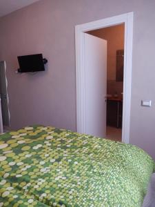 een slaapkamer met een bed en een televisie aan de muur bij Affittacamere Happy in Porto SantʼElpidio