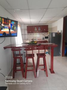 cocina con mesa de madera y 2 taburetes en Apartamento Las Margaritas, en Santa Rosa de Cabal