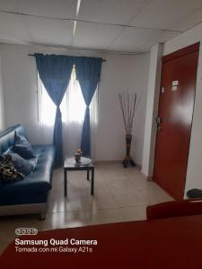 sala de estar con sofá azul y mesa en Apartamento Las Margaritas en Santa Rosa de Cabal